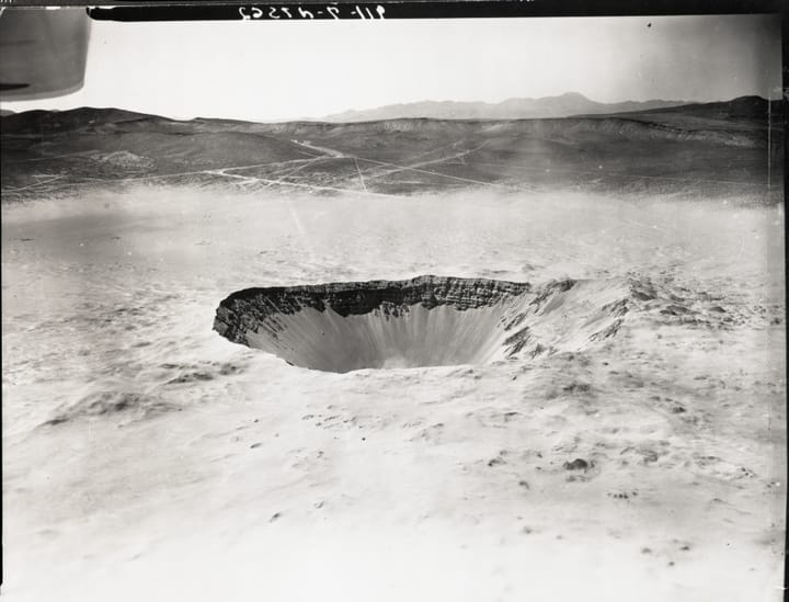 deep crater in a desert landscape, black and white